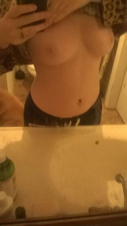 Jeune femme aux gros seins en selfie dans la salle de bain